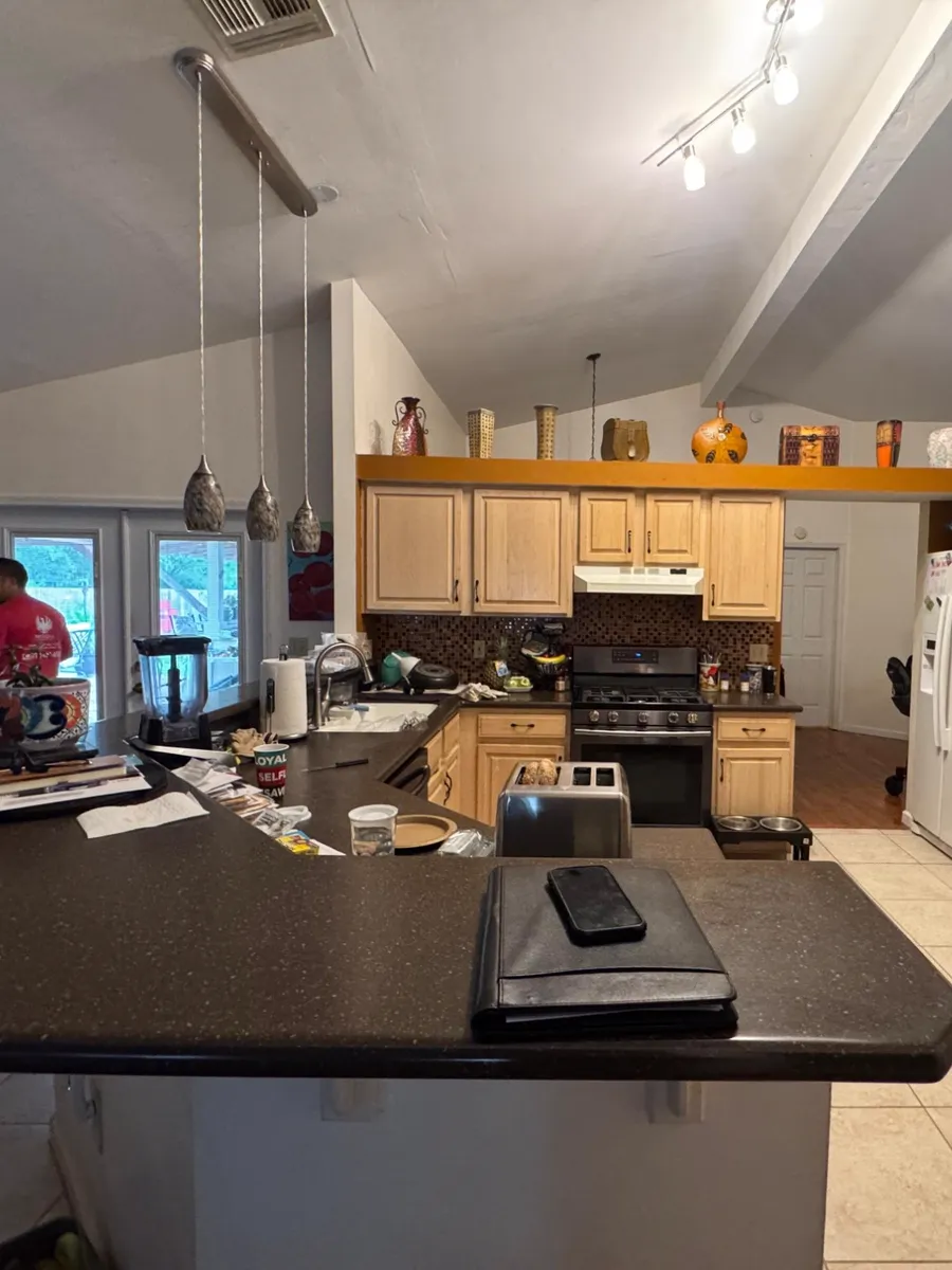 Before: dated kitchen with beige tile floor and oak cabinets in an Avondale home