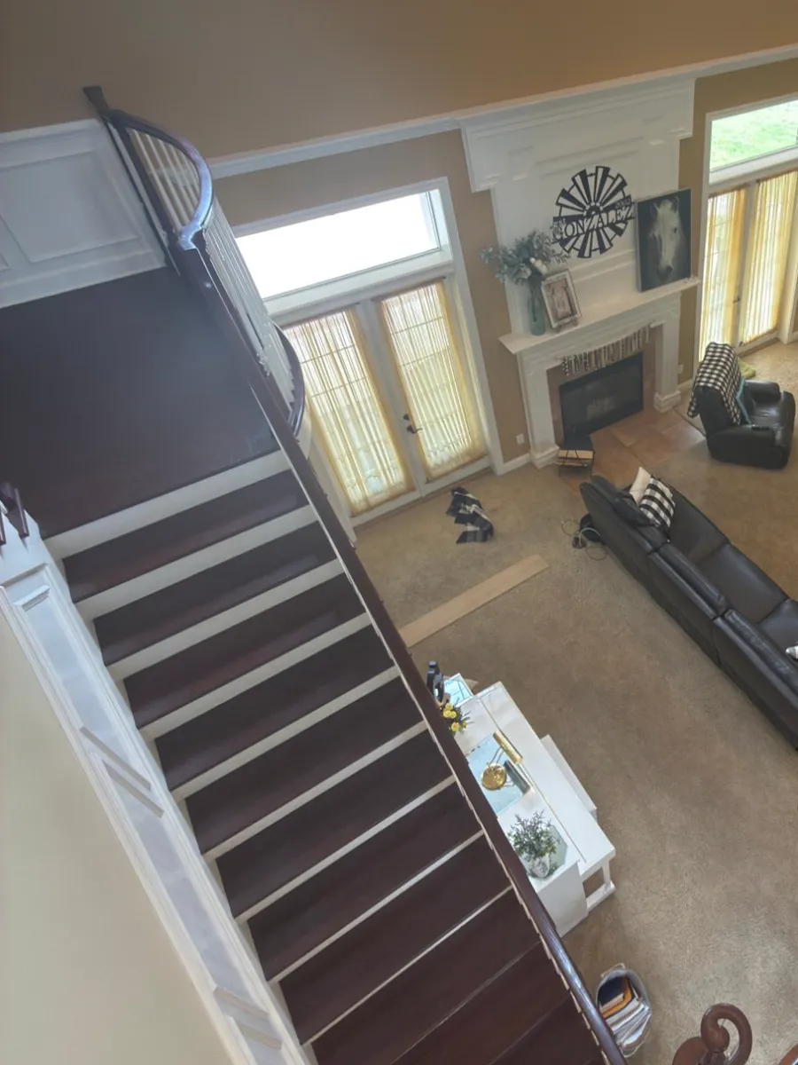 Before: carpeted staircase and carpeted great room in a Orange Park home