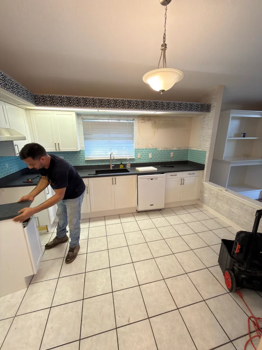 Before: dated kitchen with white ceramic tile floor, teal backsplash and old cabinets in a St. Augustine Beach home