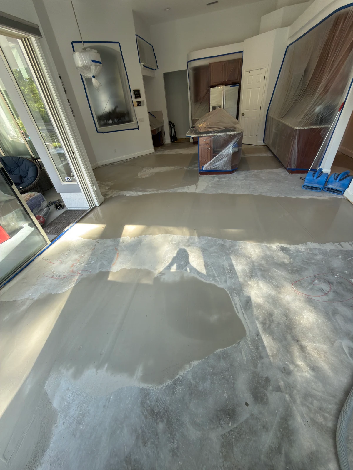 Concrete floor with visible preparation areas before glue-down wood flooring in Fernandina Beach